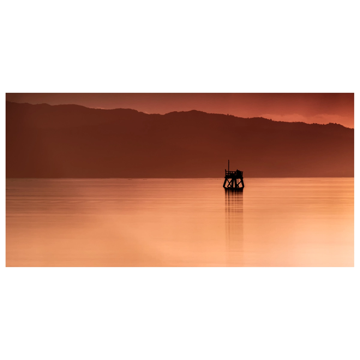 Sunset long exposure photo of the Firth of Thames, New Zealand, with smooth water and soft pastel colours.