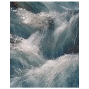 Close-up long exposure of water flowing over rocks, showing detailed movement in the stream.