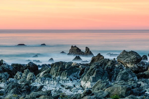 Kaikoura Rocks Sunrise – Long Exposure of Misty Sea Around Rocks with Apricot Sky