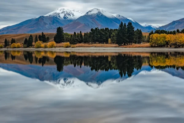 Lake Camp – Early Morning View Across Lake to Snow-Topped Mountains and Autumn Trees