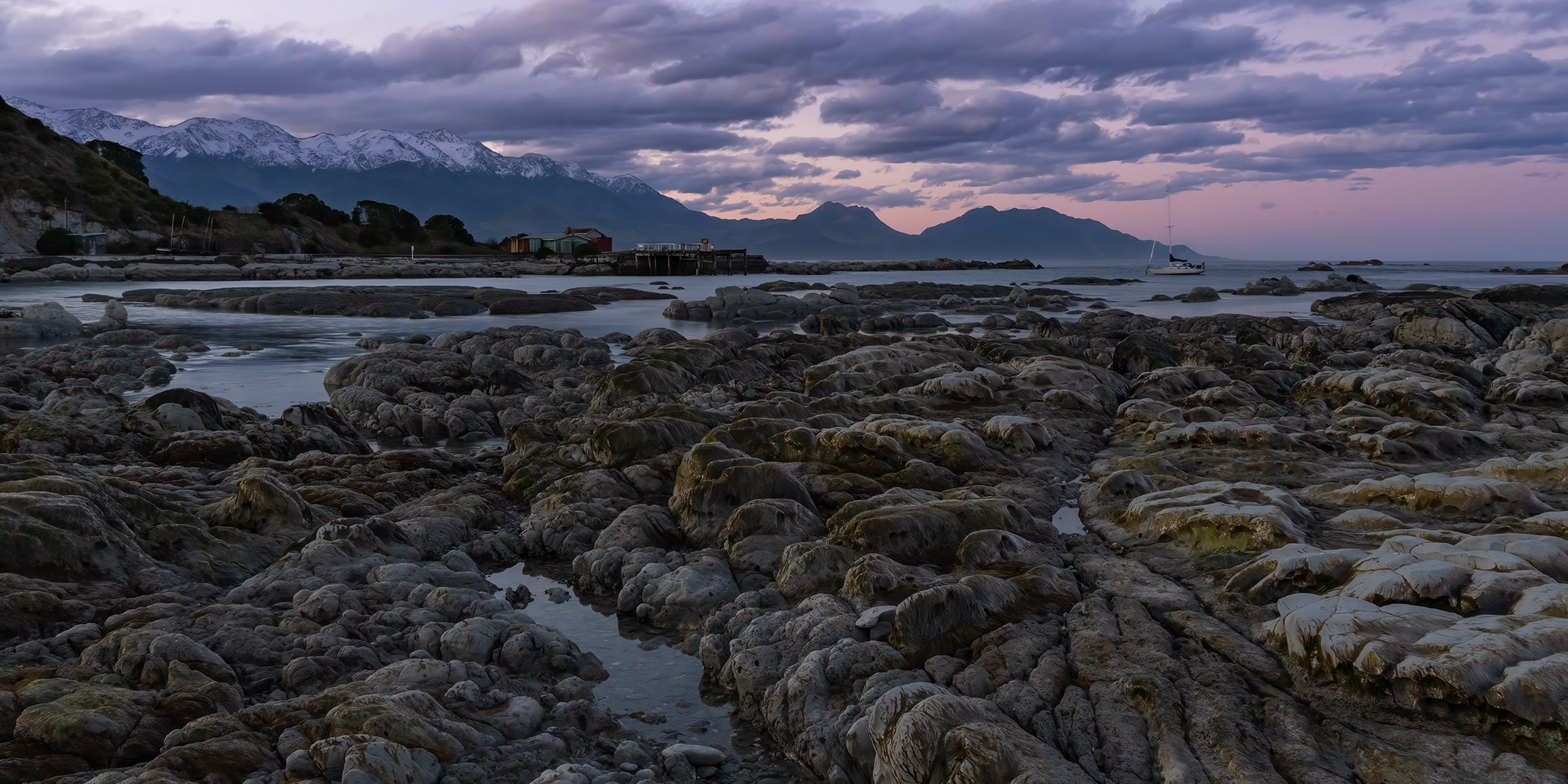 Sunset in Kaikoura – Jimmy Armers Bay Rocks with Fyfe Quay and Southern Alps